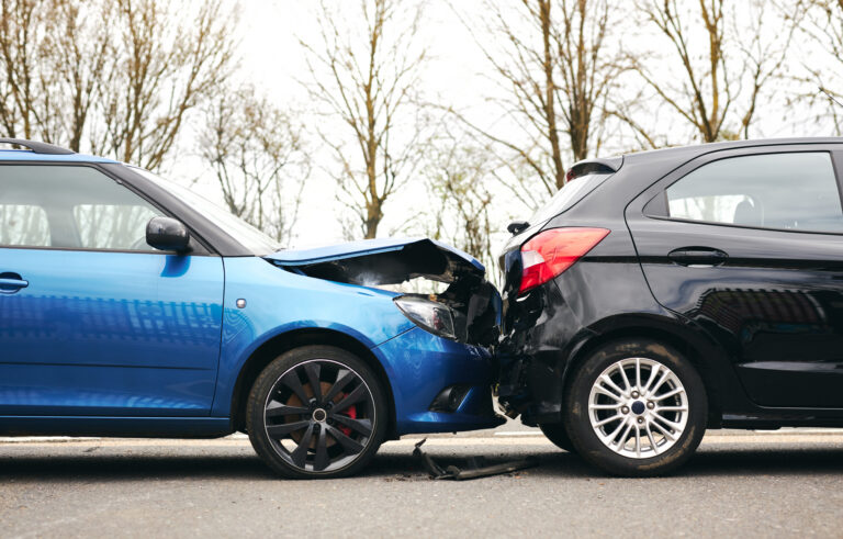 Car accident involving a blue hatchback and a black car on a road in Mexico.