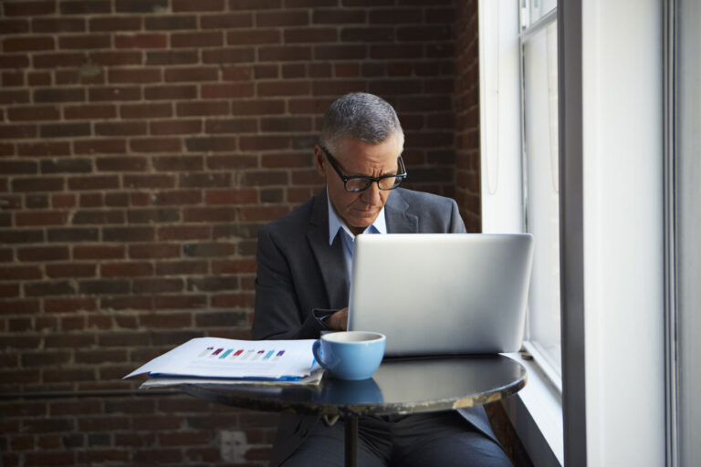 A senior corporate investor carefully analyzing market research and macroeconomic financial metrics on his laptop, evaluating capital opportunities for investing in Mexico.