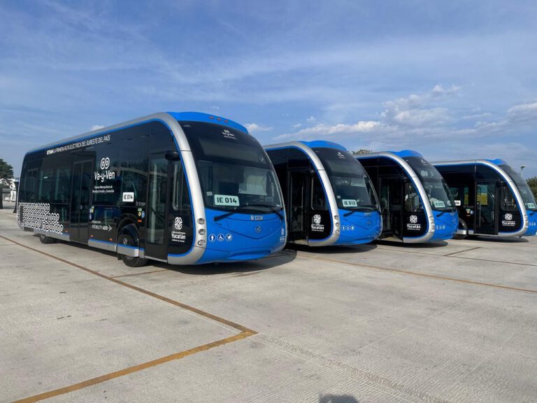 A modern fleet of blue and silver electric Ie-Tram and Va-y-Ven buses parked in an official transit terminal, showcasing public transportation systems in Merida, Yucatan.